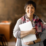 Teacher stands in classroom to become online instructor