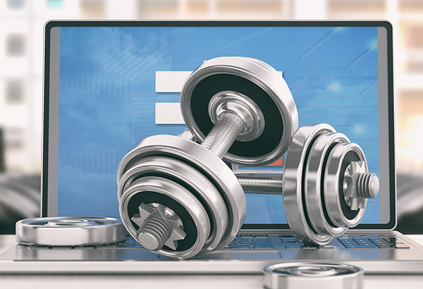 Weight-lifting weights are set on top of computer keyboard for online instructors