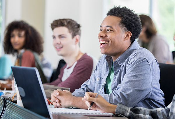 Students laugh and look in front of them using humor in the classroom