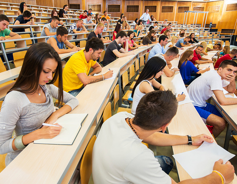 Large class lecture features numerous students taking exam
