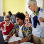 teacher-guiding-students-working-at-computer