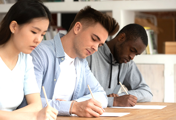 group-of-students-at-table-writing-on-paper