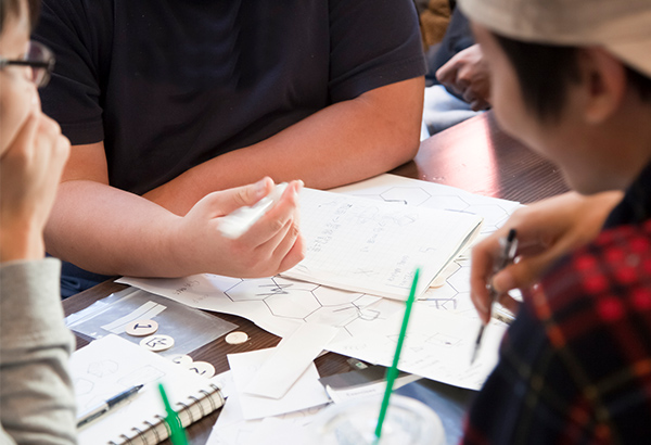 students-at-table-with-papers-taking-notes-talking