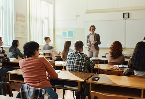 woman-in-front-of-students-at-desks-in-classroom