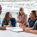 woman-at-table-with-young-people-smiling-talking