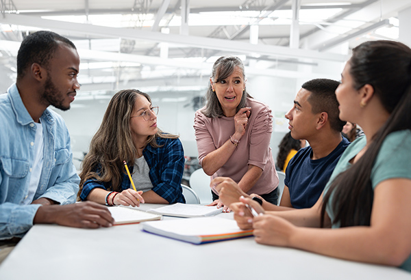 woman-at-table-with-young-people-smiling-talking